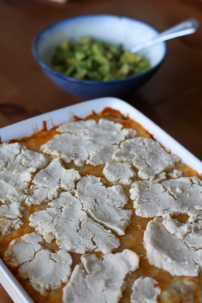 Mexican beef cobbler with bowl of avocado in backround