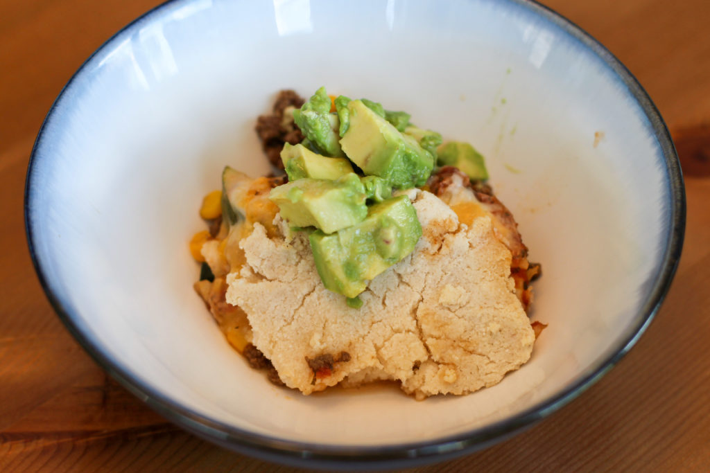 Bowl of Mexican beef cobbler topped with avocado