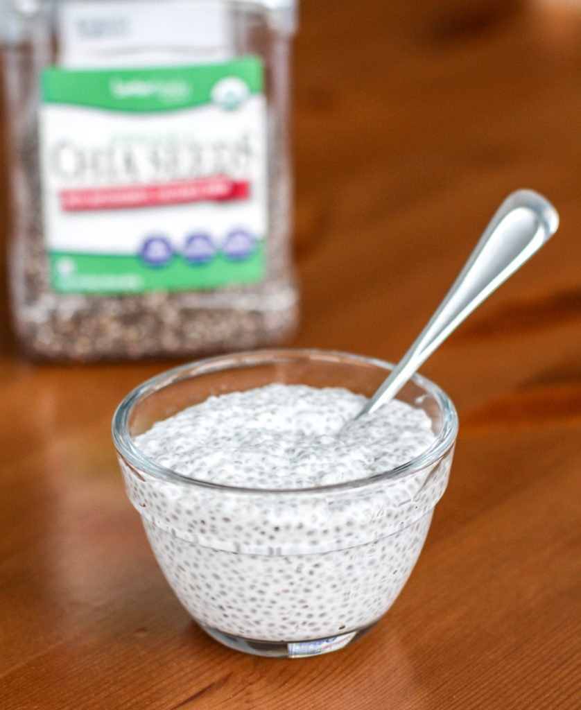 Bowl of vanilla chia seed pudding with container of chia seeds in background