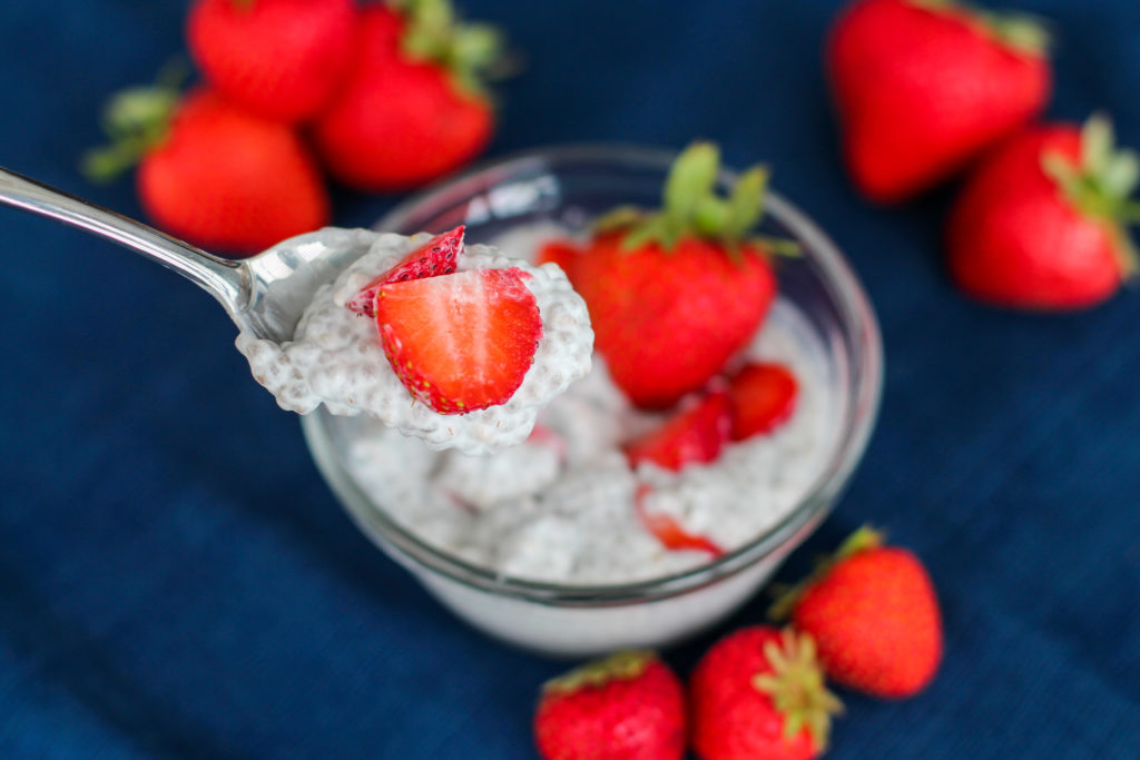 Spoon with strawberry cheesecake chia seed pudding