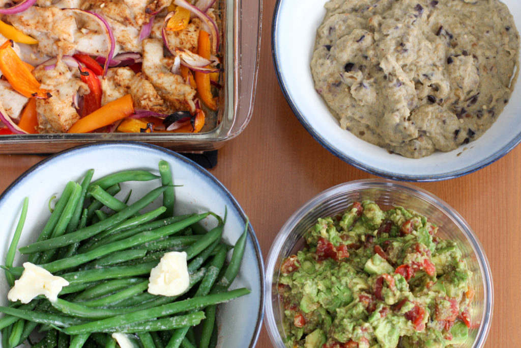 Table set with chicken fajitas, bean-less refried beans, guacamole, and green beans