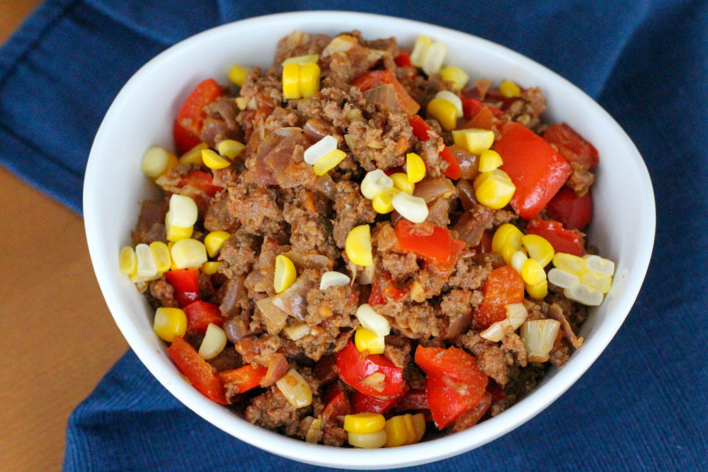 Homemade taco meat with corn and red bell pepper in white bowl