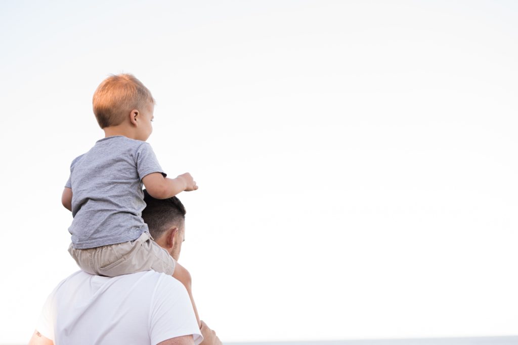 child riding on dad's shoulders