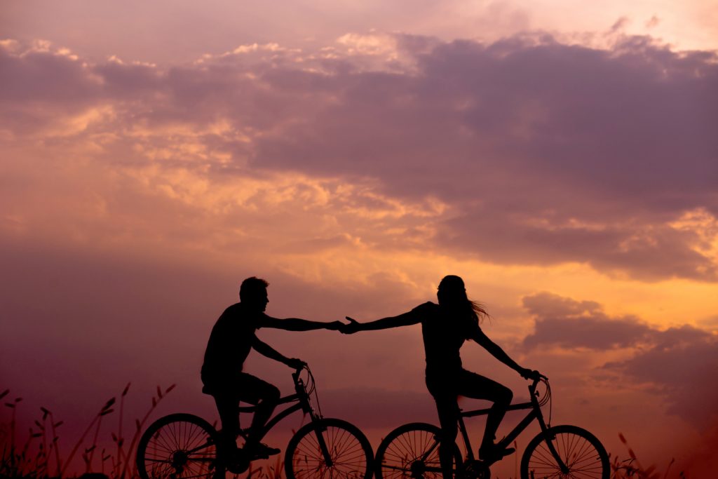 couple on bikes at sunset