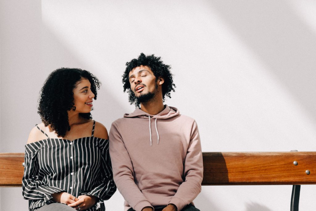 couple talking on wood bench