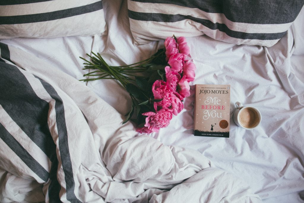 flowers, book and coffee lying on bed - 5 love languages gifts