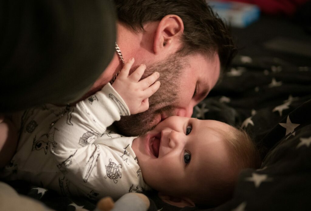 dad kissing little girl who is smiling