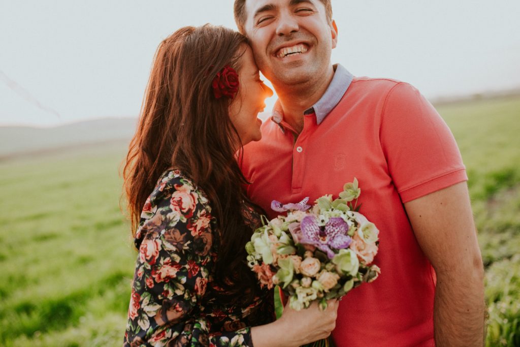 woman holding flowers with man