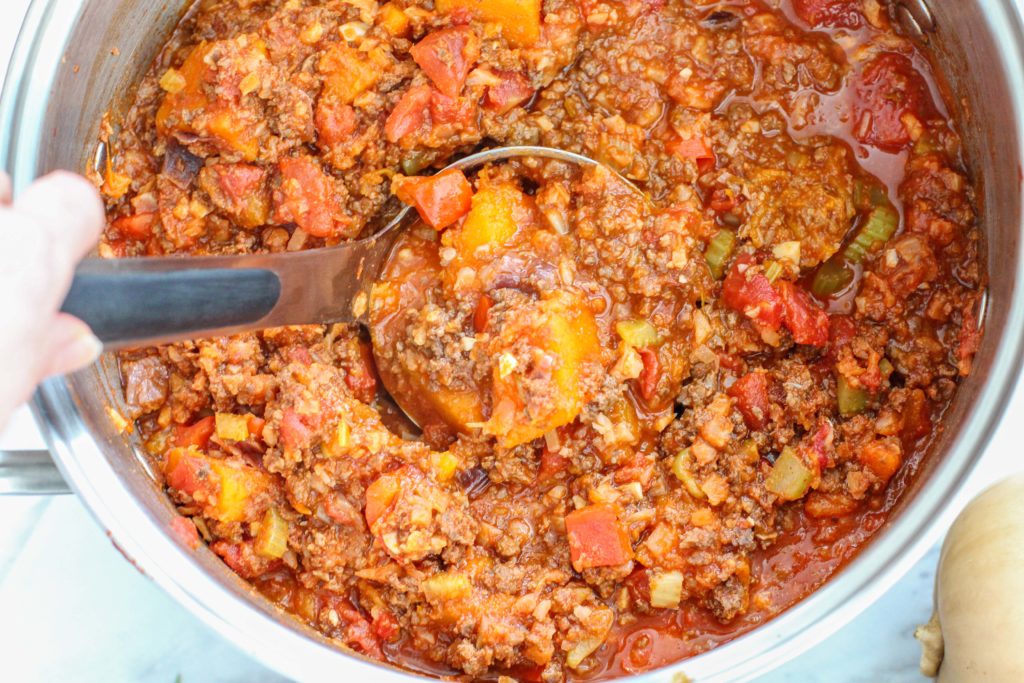 Ladle scooping butternut squash chili