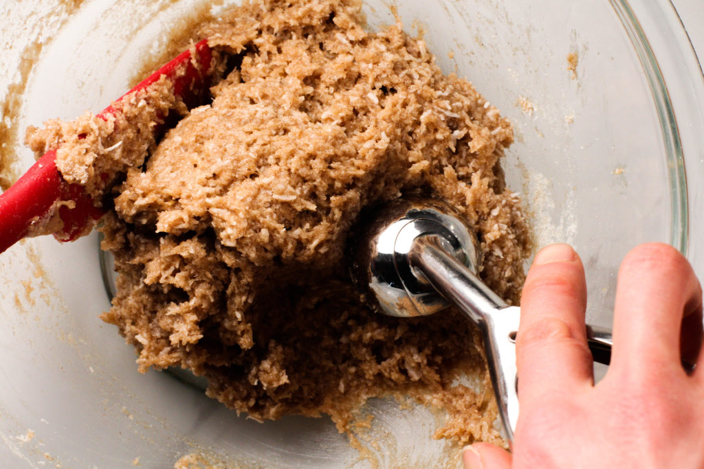 cookie scoop reaching into bowl of banana bread protein bites dough