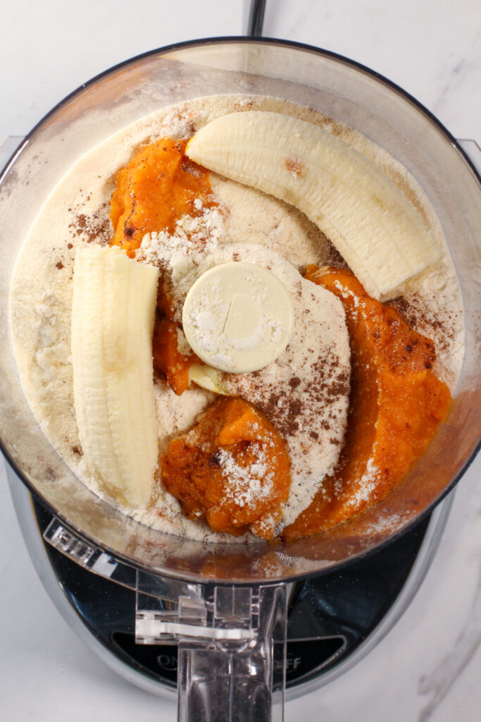 food processor filled with pumpkin pie truffle ingredients