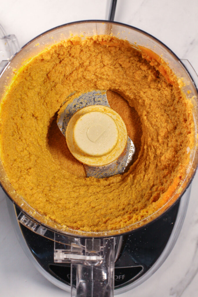 food processor filled with blended pumpkin pie truffle ingredients