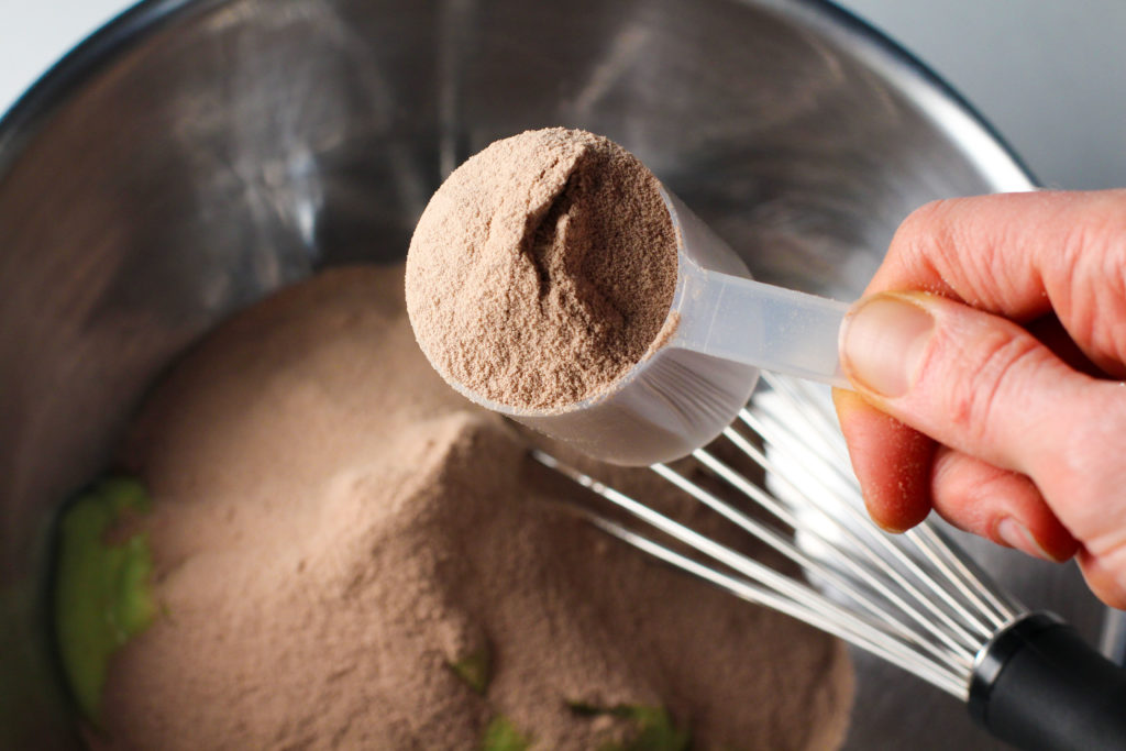 hand scooping out protein powder
