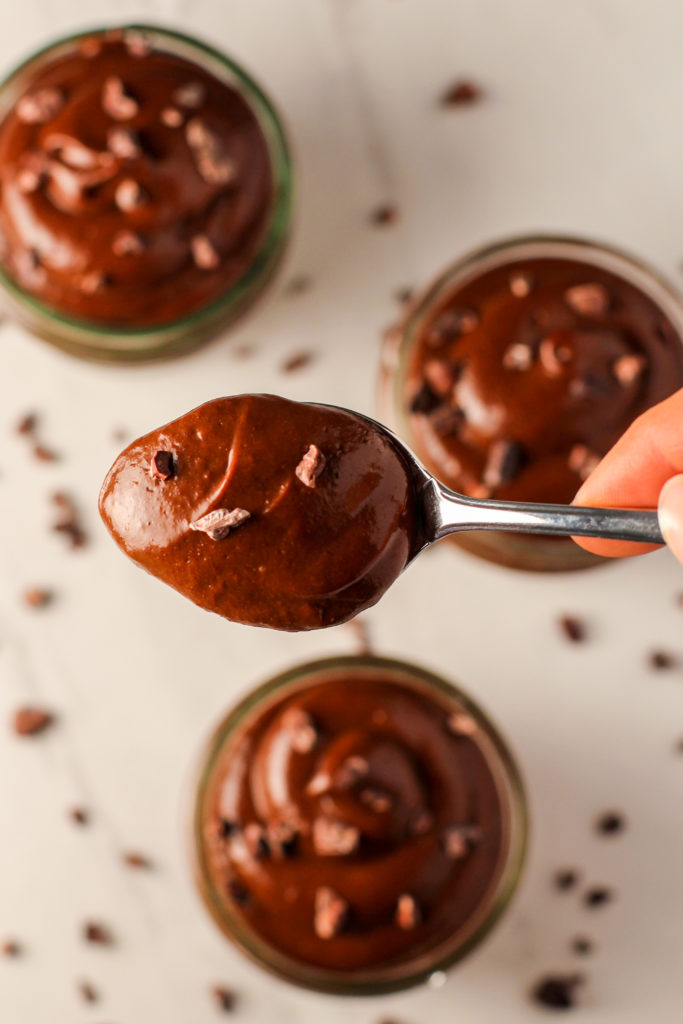 spoon holding chocolate avocado pudding