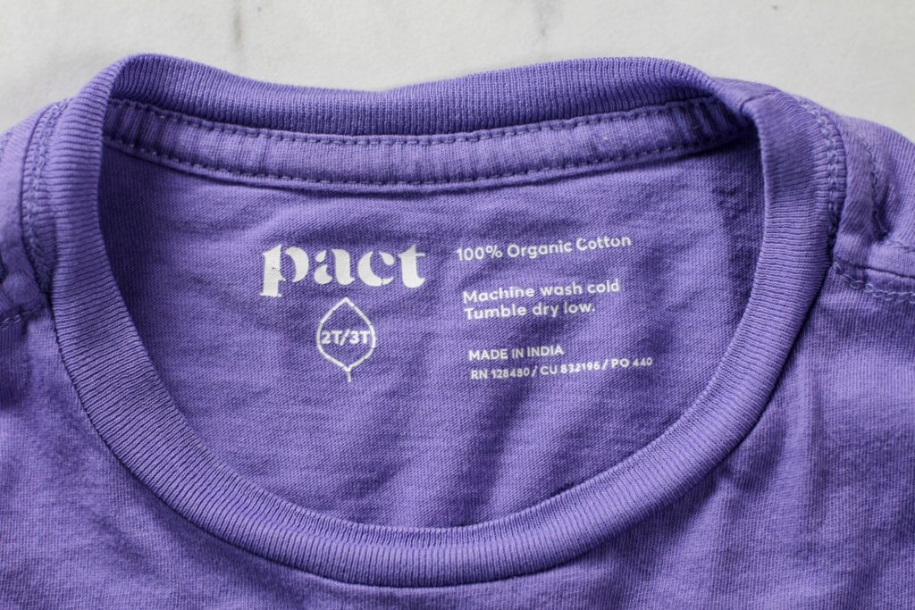 Pact 100% cotton on purple tshirt label