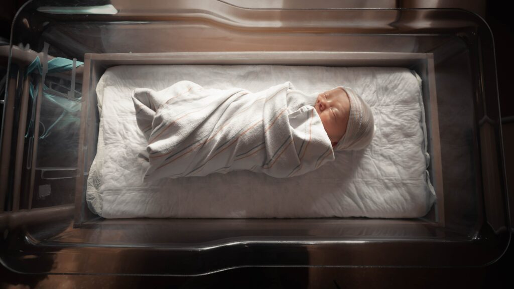 baby laying in hospital bassinet