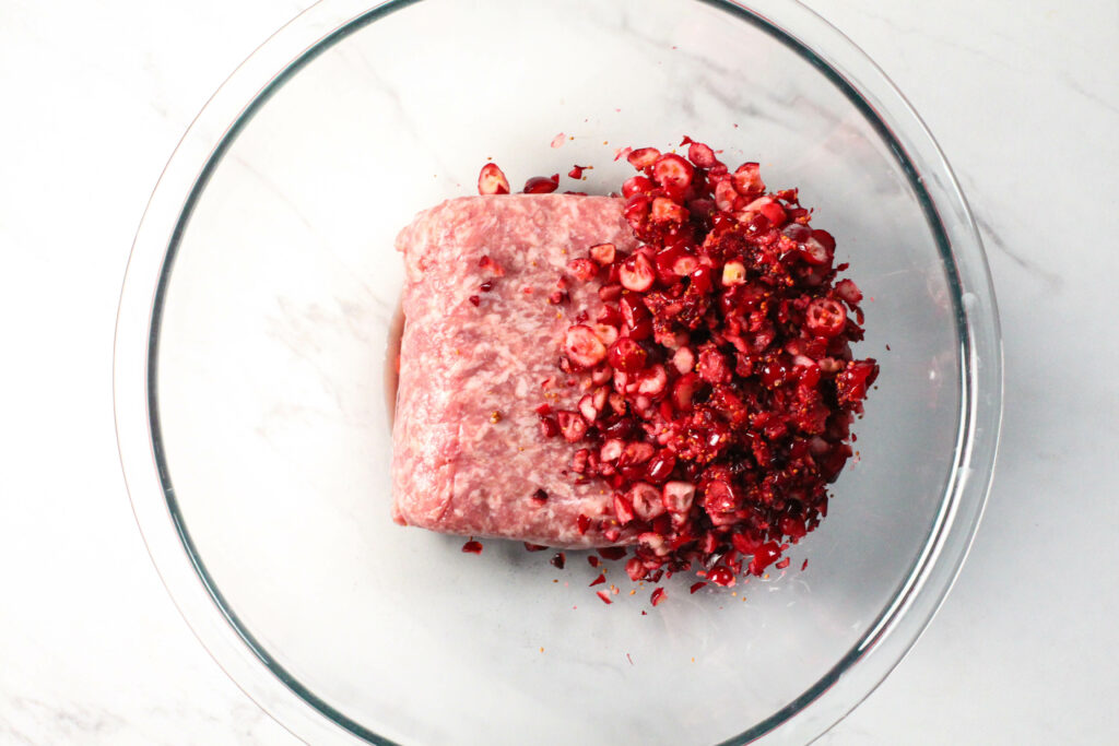 glass bowl with chopped cranberries and ground pork
