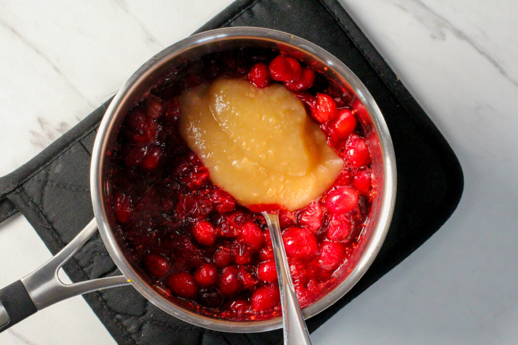 saucepan with cooked cranberry sauce and applesauce