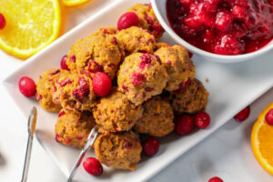 pile of cranberry orange meatballs next to dipping sauce