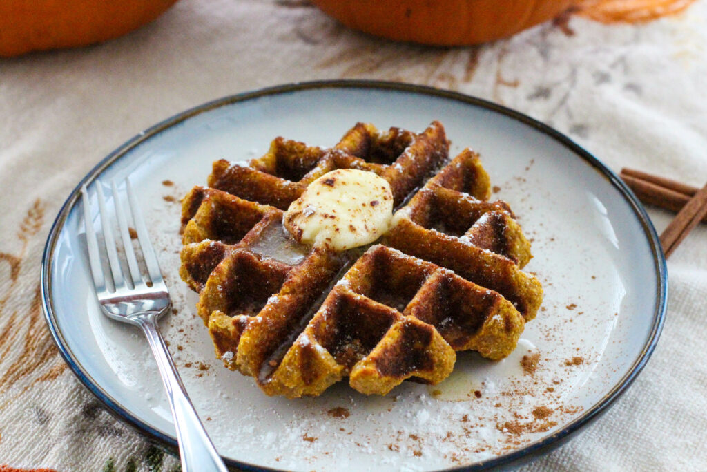 plate with pumpkin waffle topped with butter