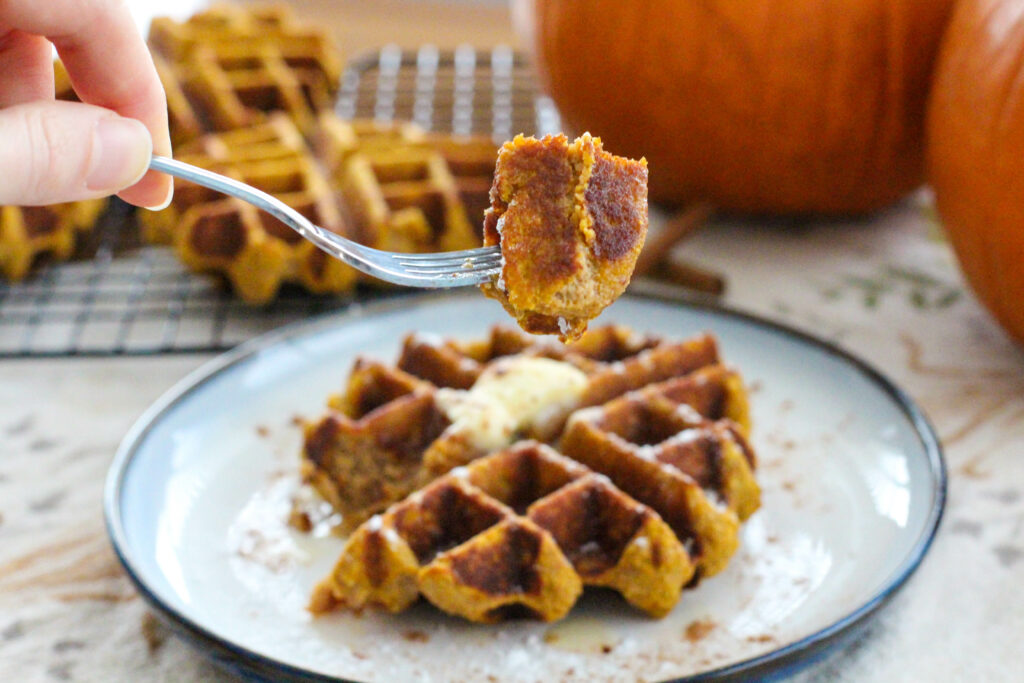 fork holding a bite of pumpkin waffles