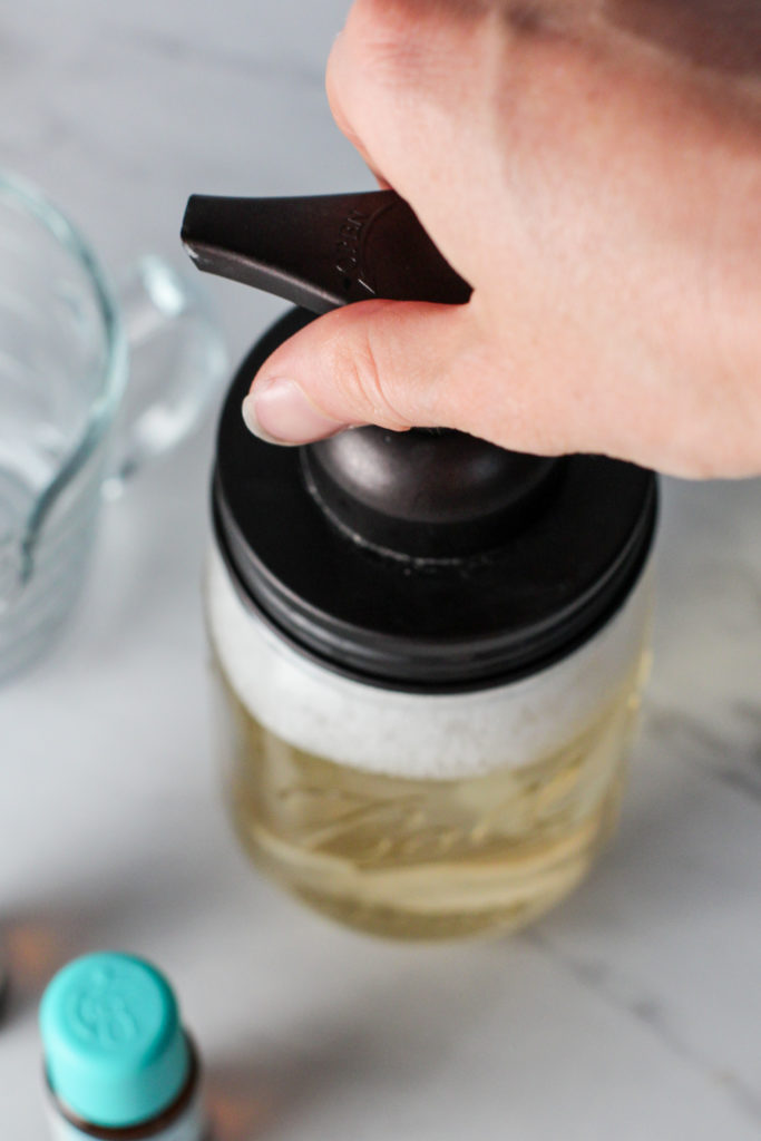 hand screwing on foaming soap dispenser