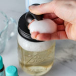 hand pressing down on foaming soap dispenser