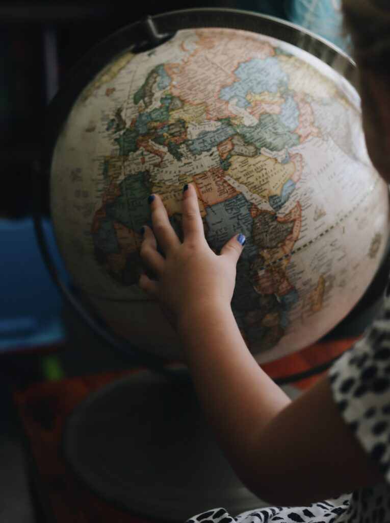 little girls hand on globe