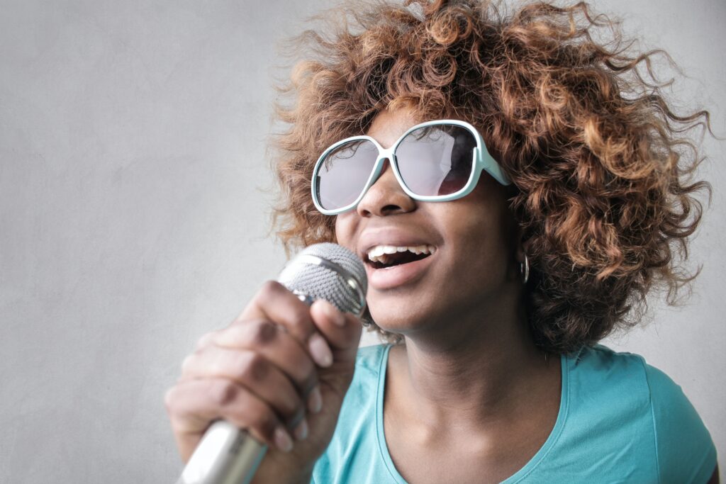 lady with sunglasses holding microphone singing