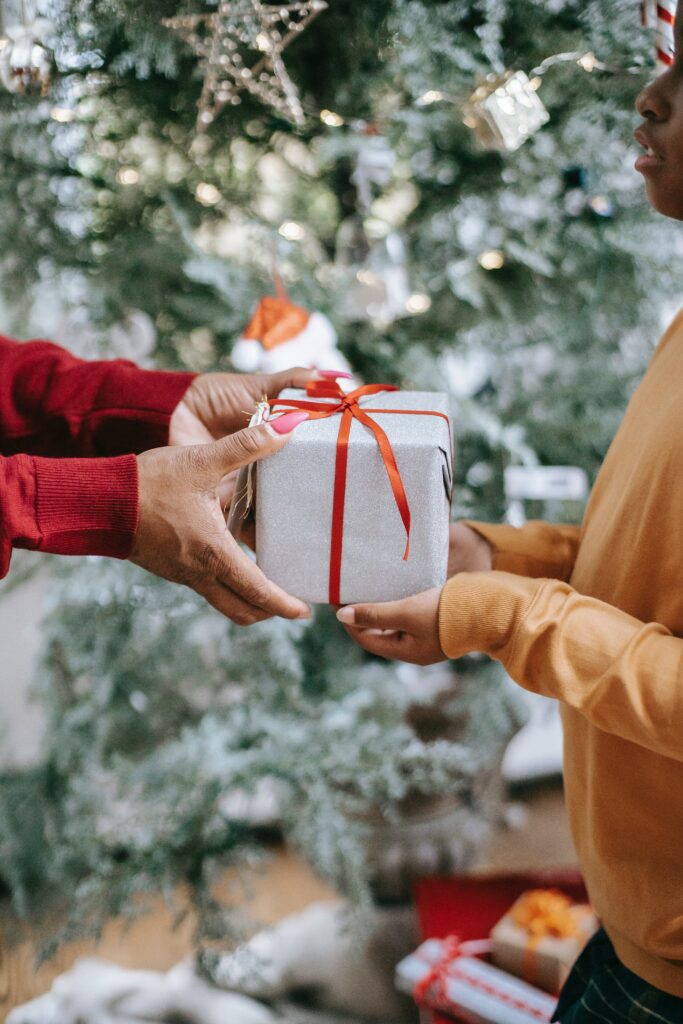 mom handing gift to child