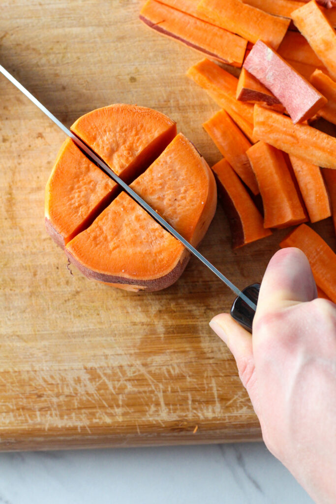 knife cutting X in sweet potato piece