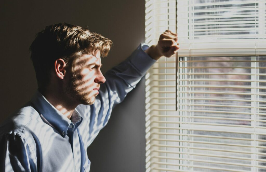 man staring out window