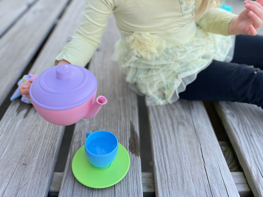 child's hand holding teapot for easy backyard water activities