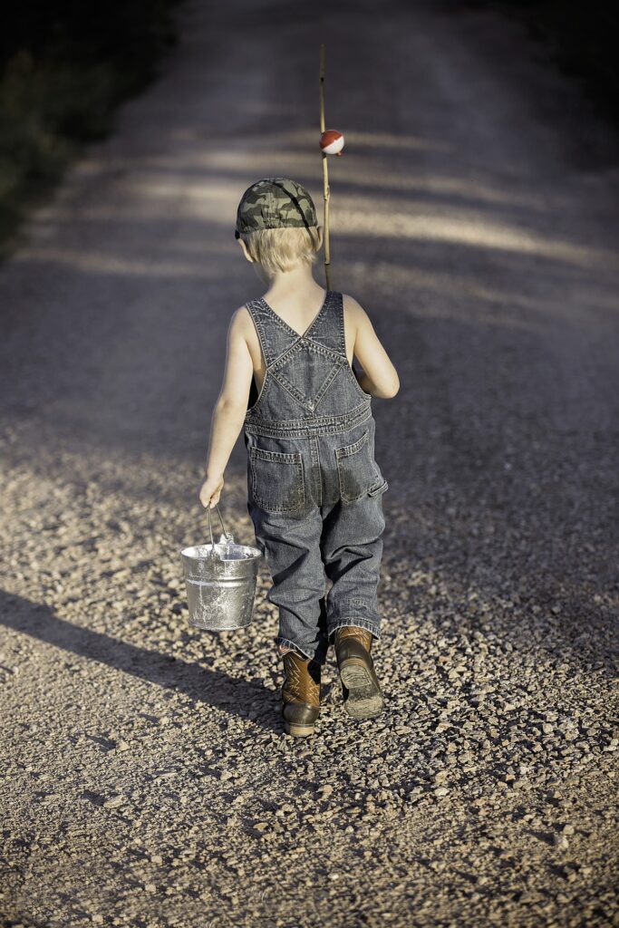 boy walking with fishing pole