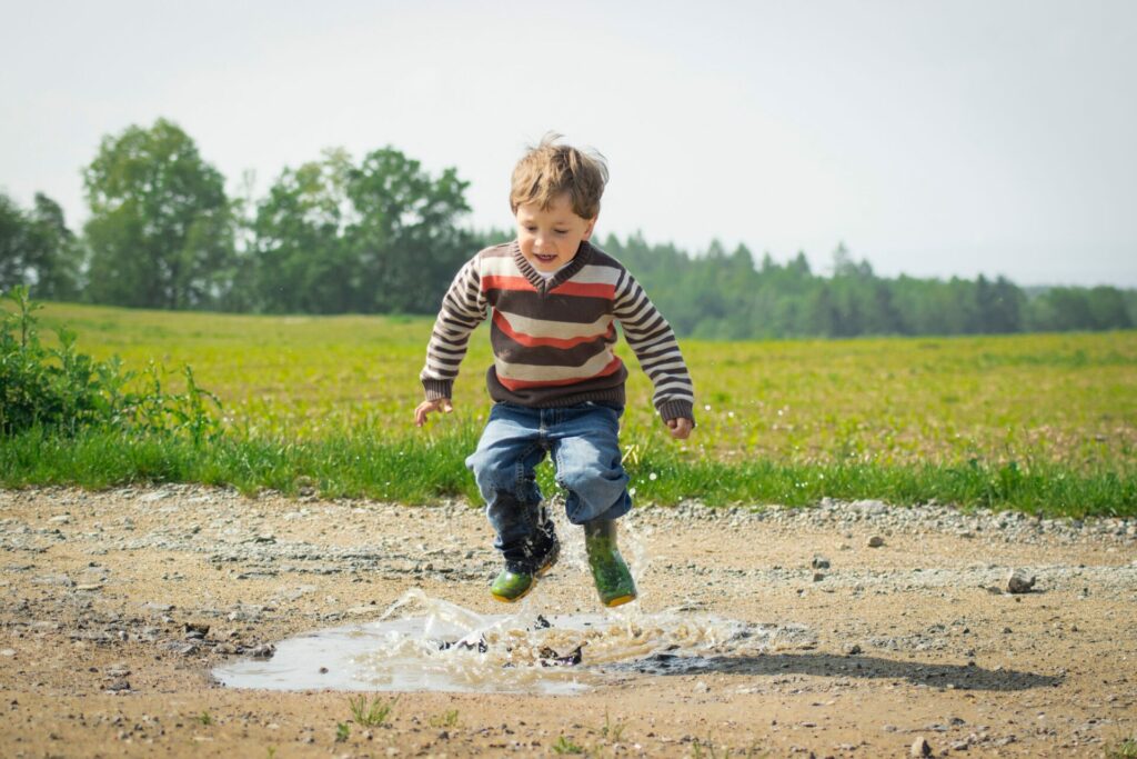 kid stomping in rain puddle