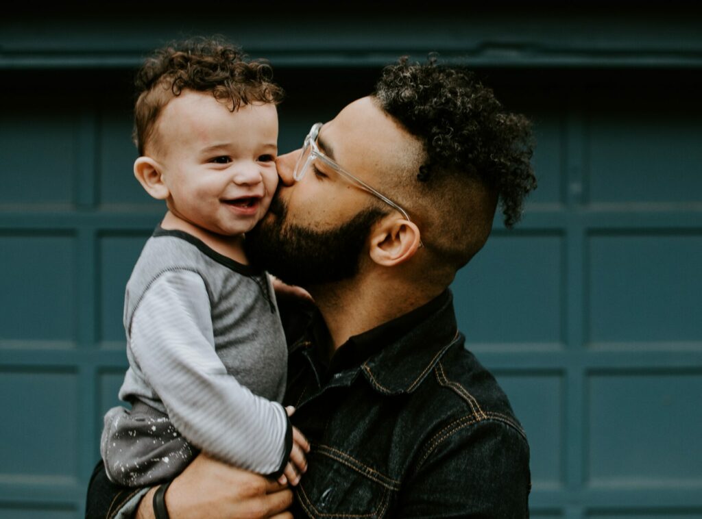 dad kissing sons check