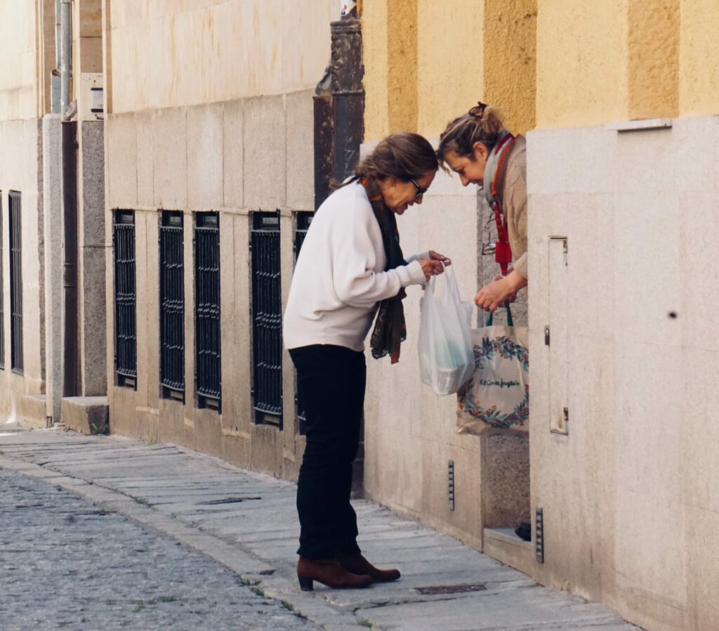 two women holding bags and peering inside them