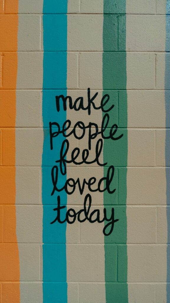 wall with striped paint that says make people feel loved today