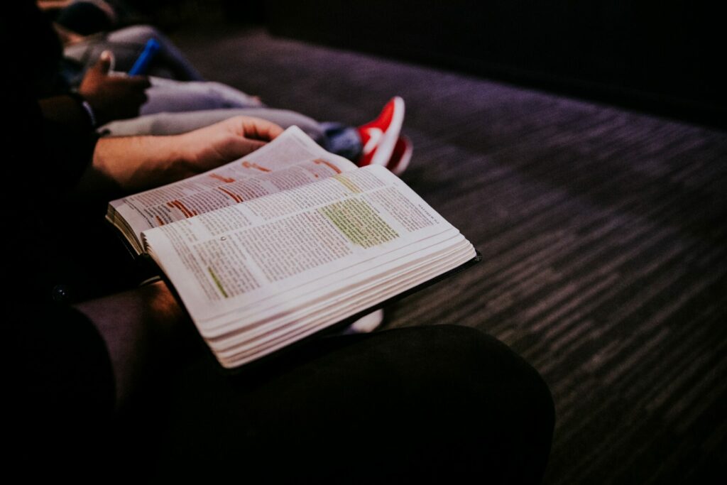 person holding a Bible that has been underlined and highlighted