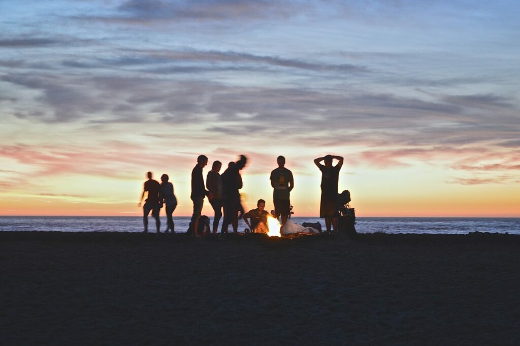 group of people at beach around a fire