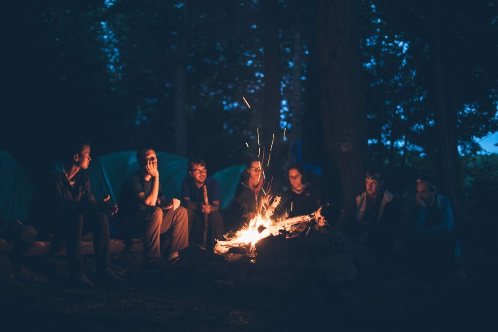 group of people around campfire in woods