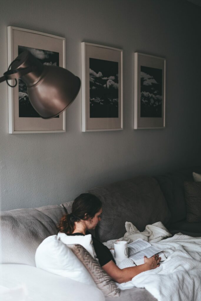 woman holding cup of coffee and reading her Bible