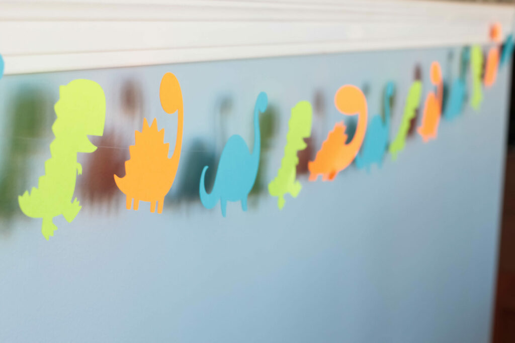 dinosaur garland hanging along blue wall