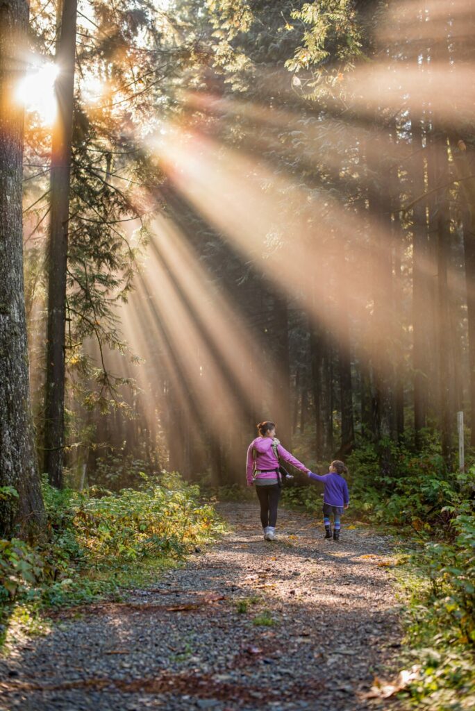 mom and child walking through forest