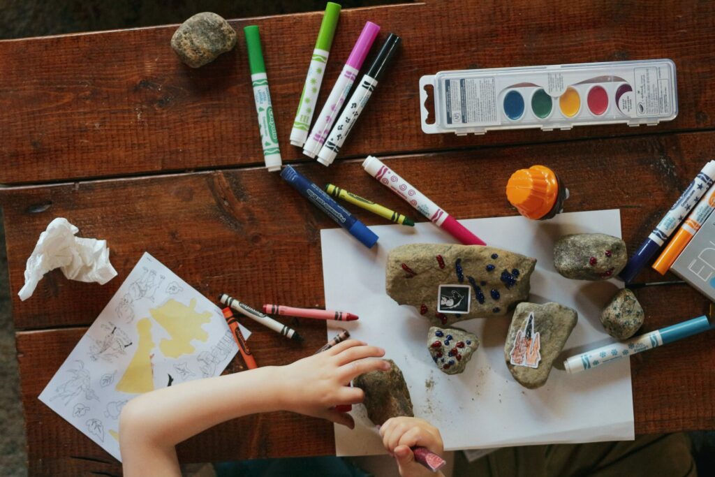 table full of art supplies and rocks for outside fun